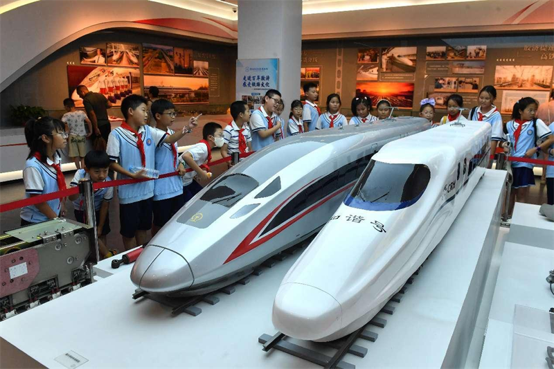 Des enfants de l'école primaire de la rue Kaiping à Qingdao, dans la province du Shandong (est de la Chine), regardent des maquettes de trains à grande vitesse Fuxing (??Renaissance??) et Hexie (??Harmonie??) au Musée ferroviaire de Jiaoji. (Wang Haibin / Pic.people.com.cn)